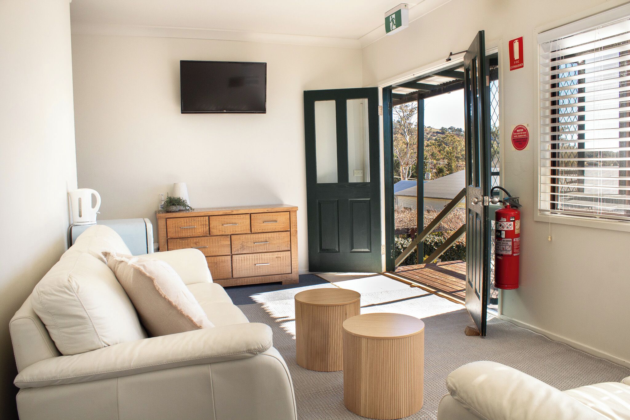 Une chambre d’hôtel moderne, équipée d’un canapé, d’une commode en bois et d’un téléviseur.