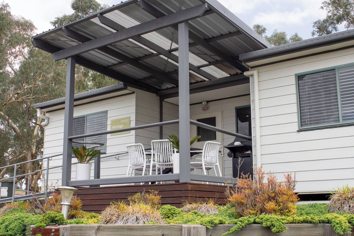 A covered outdoor area with chairs and a potted plant.