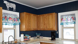 Una cocina con armarios de madera, un lavamanos de acero inoxidable y una cafetera.