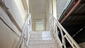 Eine Treppe mit weißen Geländern und beigen Fliesen.