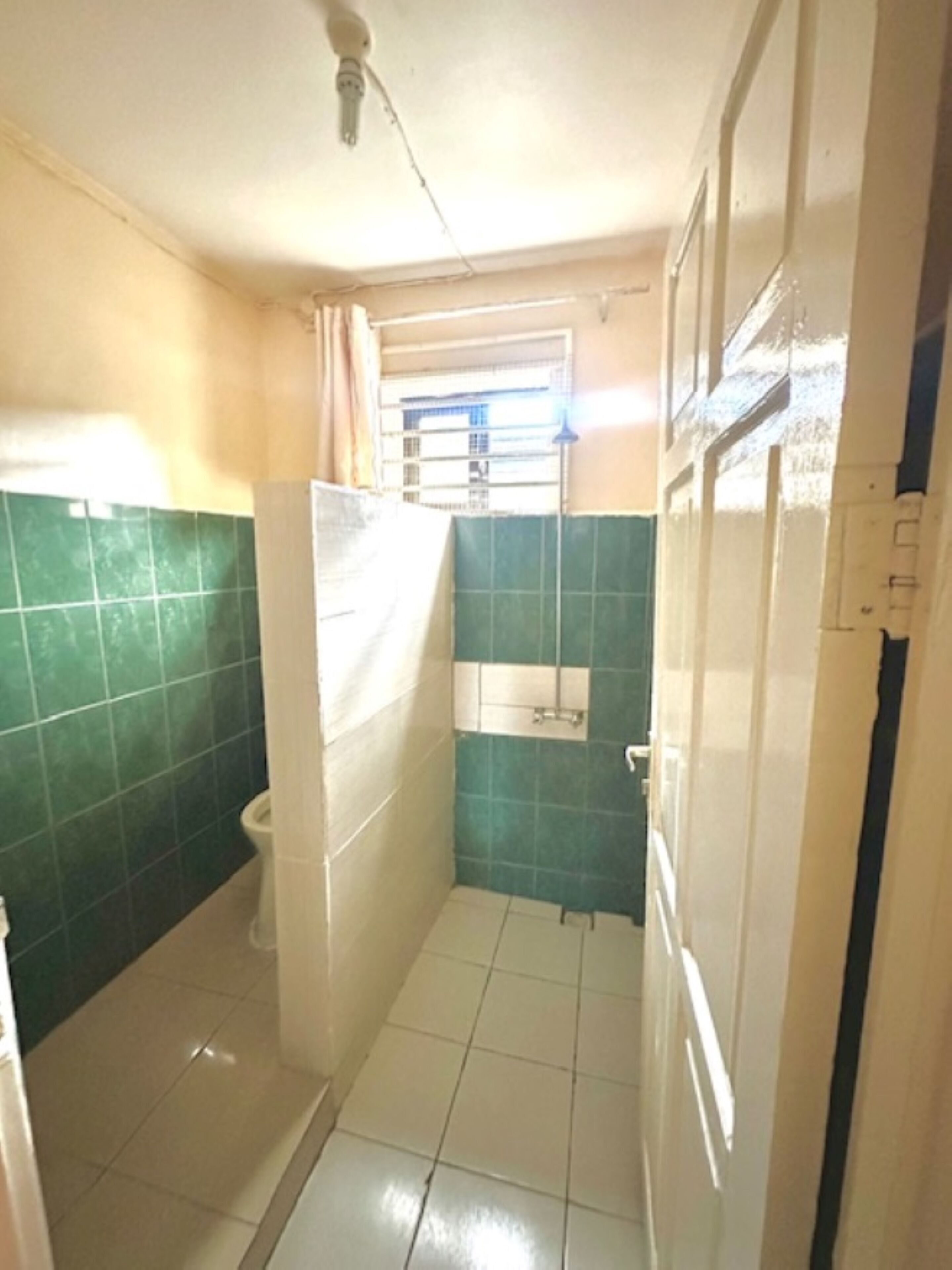 A small bathroom with a toilet, a shower, and a sink.