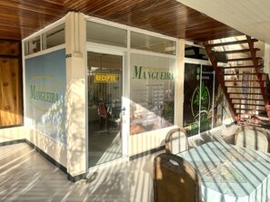 A hotel entrance with a reception area, a staircase, and a table with chairs. - Hotel Mangueira (Paramaribo)