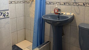 A bathroom with a shower, a sink, and a toilet. - Natys guest house (Cusco)