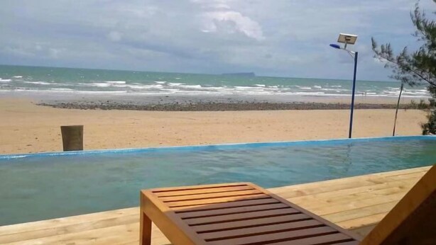 A wooden deck with a pool overlooking a beach. - Beihai Weizhou Xiaodeng Yujiale (Beihai)
