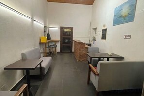 A narrow hallway with seating arrangements, a staircase, and a door leading to another area. - Beihai Weizhou Xiaodeng Yujiale (Beihai)