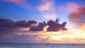 A sunset over a coastal area with a bridge in the distance. - Beihai Weizhou Xiaodeng Yujiale (Beihai)