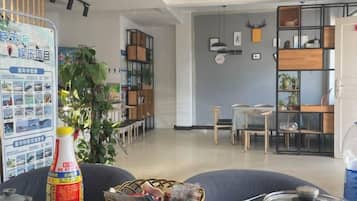 A modern interior with a dining area, a bookshelf, and a bulletin board.