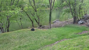 A grassy area with trees and a body of water. - New River RV Travel Trailer with 1 King bedroom and bunks - 2 small children. (Prince)