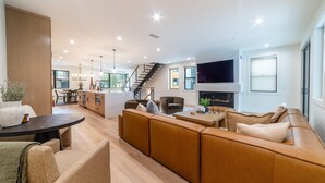 Ein modernes Wohnzimmer mit einer Couch, einem Esstisch und einer Treppe zu einer weiteren Ebene.