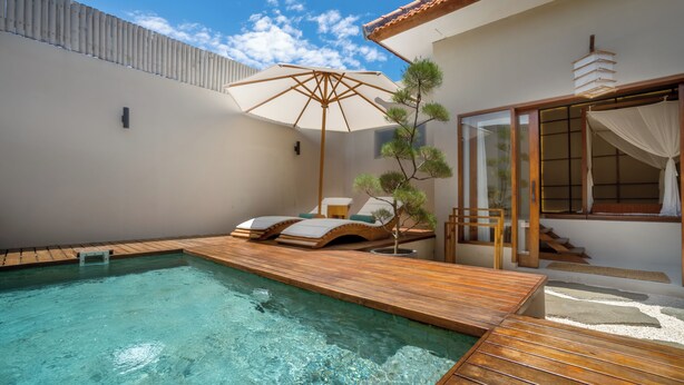 A swimming pool with wooden deck, lounge chairs, and a pergola. - YŪN Uluwatu (Pecatu)