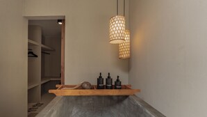 A bathroom with a wooden tray holding toiletries, a towel, and a sink. - YŪN Uluwatu (Pecatu)
