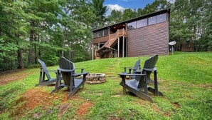 Eine moderne Blockhütte mit einer Terrasse und einem Sitzbereich im Freien.