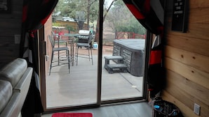 A room with a sliding glass door leading to an outdoor patio area. - Relaxing 2-bedroom cabin decorated with Coke Cola Theme, (Payson)