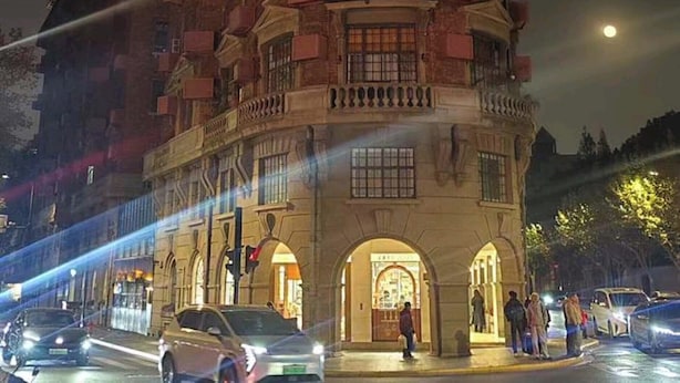 A multi-story building with a curved facade, large windows, and a prominent entrance with an arched doorway. - Philosopher Hotel (Shanghai)