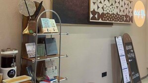 A reception area with a modern design, including a reception desk, a wall-mounted information board, and a decorative wall panel. - Philosopher Hotel (Shanghai)