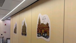 A hallway with a series of wall-mounted posters depicting traditional architecture. - Philosopher Hotel (Shanghai)