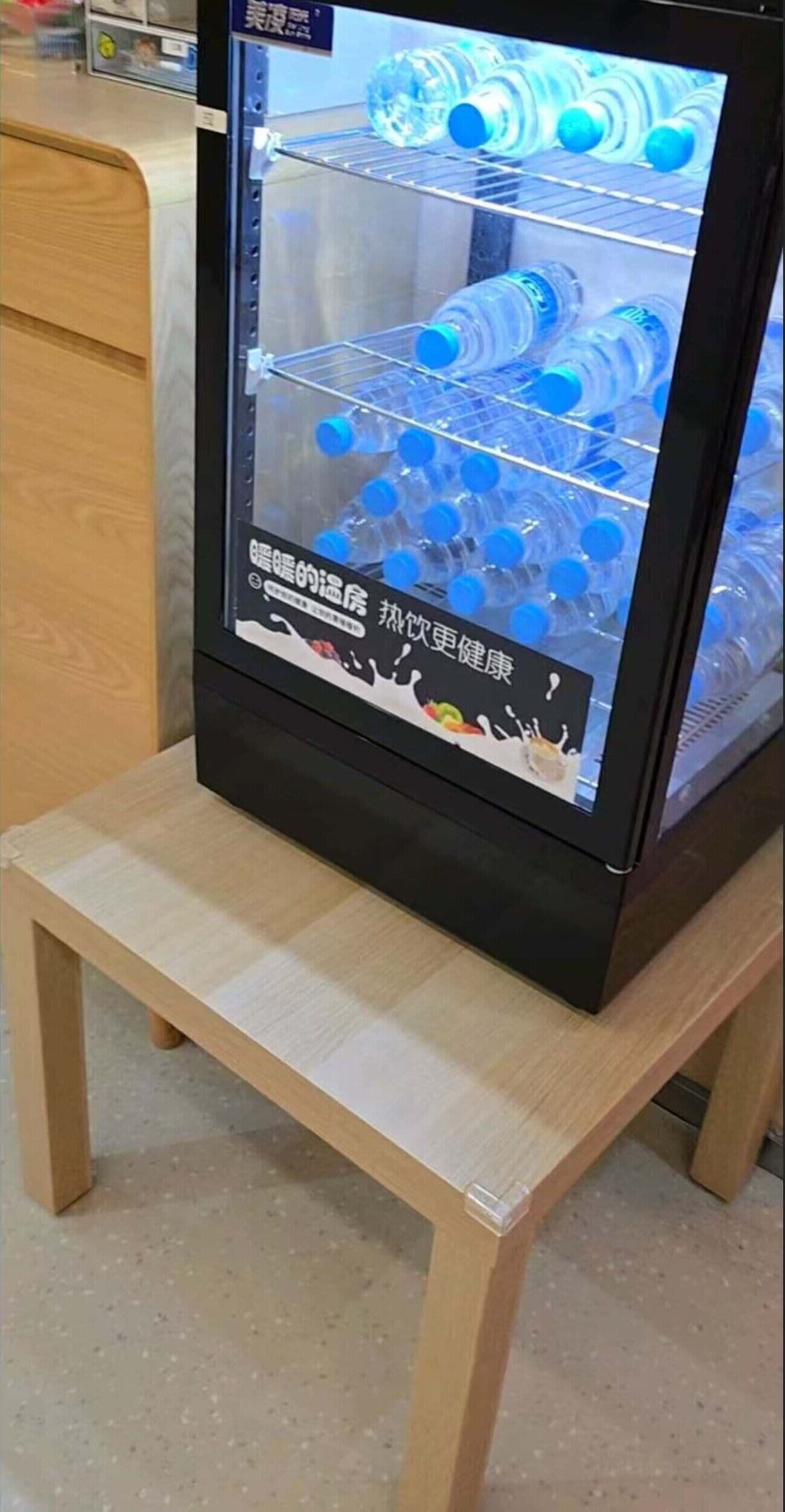 A vending machine with a glass front displaying bottled water.