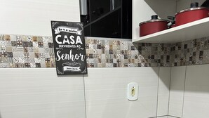 Une cuisine équipée d’une cuisinière, d’une machine à café et d’une affiche accrochée au mur.