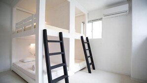 A bunk bed room with white walls, a window, and an air conditioning unit. - LANAIHOTEL & DORMITORY  (Naha)