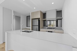 A modern kitchen with a central island, built-in appliances, and a view of the city.