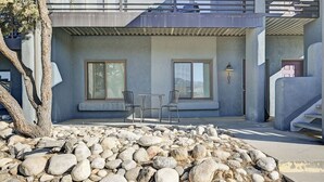 A modern building with a stone facade, two windows, and a seating area with chairs. - Downtown 2BD 1BA - 2 Blocks to Main/River #187 (Buena Vista)