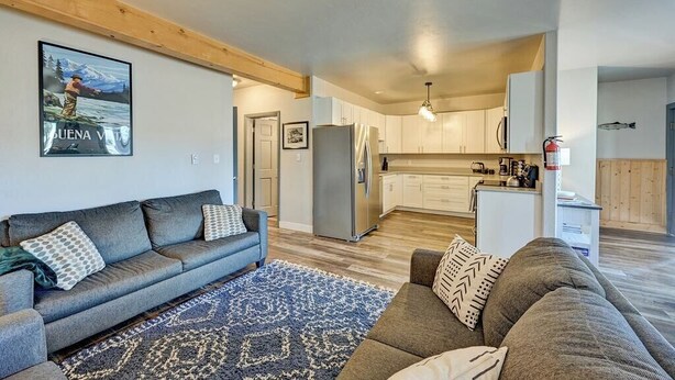 A modern living space with a sofa, a rug, a kitchen area, and a dining table. - Downtown 2BD 1BA - 2 Blocks to Main/River #187 (Buena Vista)