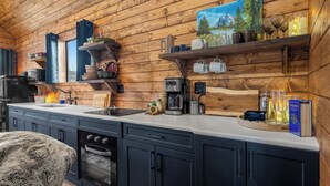 Een moderne keuken met houten wanden, een inbouwoven en diverse apparaten.