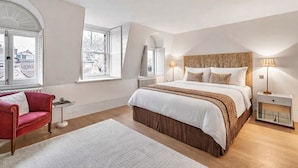 A bedroom with a large bed, a red armchair, and a white rug. - The Mayfair Penthouse Private Elevator Large Rooftop Terrace Central AC (London)