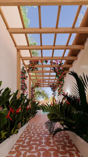 A covered walkway with a wooden pergola, surrounded by lush tropical plants and flowers. - Villa Meru (Seminyak)