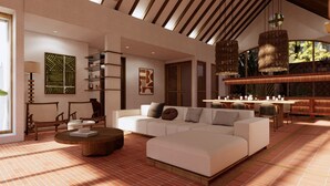 A spacious living area with a large white sofa, a round coffee table, and a dining area with a long table and chairs. - Villa Meru (Seminyak)