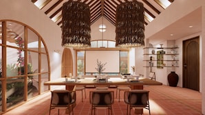 A modern dining area with a large table, six chairs, and a hanging light fixture. - Villa Meru (Seminyak)