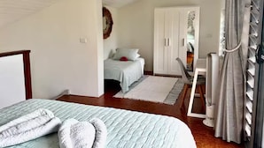 Ein Schlafzimmer mit zwei Betten, einem Schreibtisch und einem Kleiderschrank.