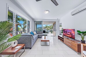 Departamento Deluxe, balcón, vista al mar | Área de sala de estar | Televisión de 55 pulgadas con canales por cable 