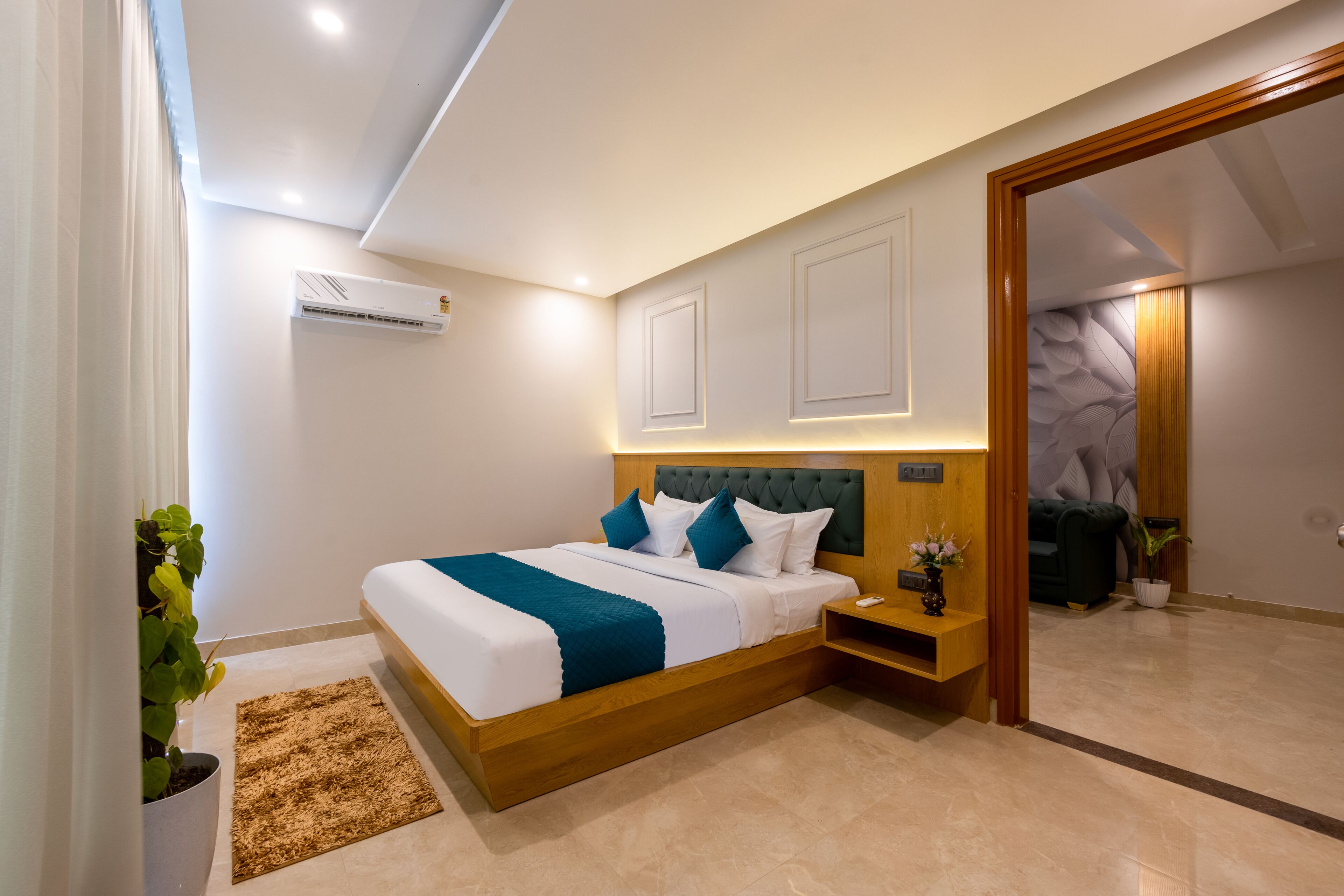 Une chambre moderne avec un grand lit, des tables de chevet, un appareil de climatisation et une vue sur une autre pièce.