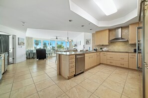 A spacious kitchen with a large island, wooden cabinets, and a modern design. - Caribe C213 - Gulf Front 3BR, Lazy River, Indoor/Outdoor Pools, 2 Min To Beach (Orange Beach)