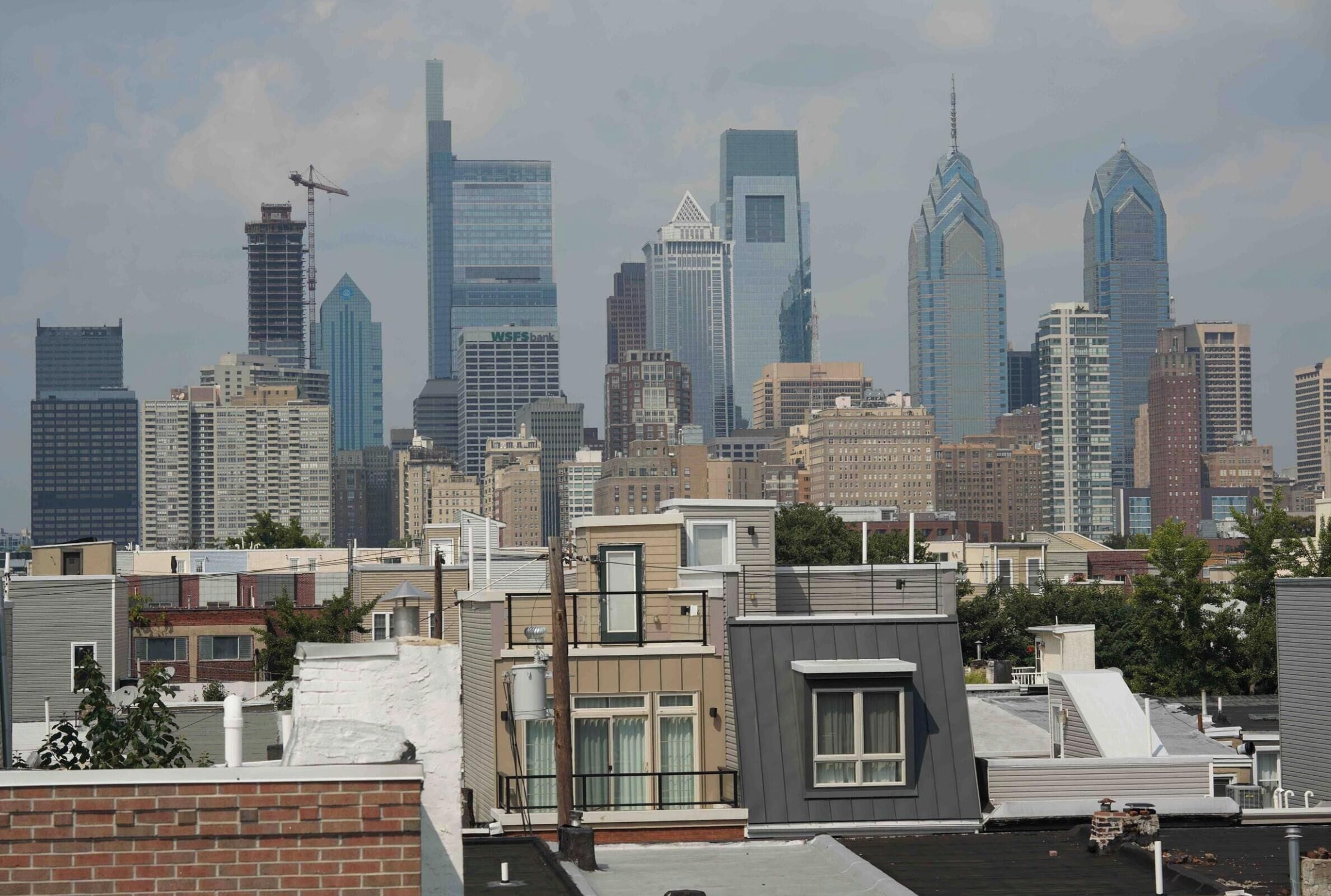 Lo skyline di una città con moderni grattacieli, tra cui una guglia caratteristica.