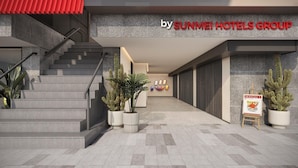 Ein Hotel Eingangsbereich mit Treppe, Pflanzgefäßen und einem Schild für die Sunmei Hotels Group.