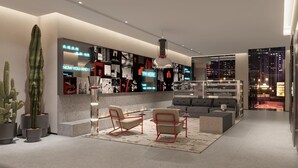 Ein modernes Interieur mit einer Sitzecke, einer großen Sukkulente und Blick auf die Stadt durch die Glaswand.