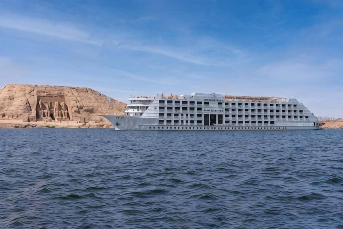 Ein großes Kreuzfahrtschiff mit mehreren Decks und einem markanten Bug, das auf ruhigem Wasser fährt.