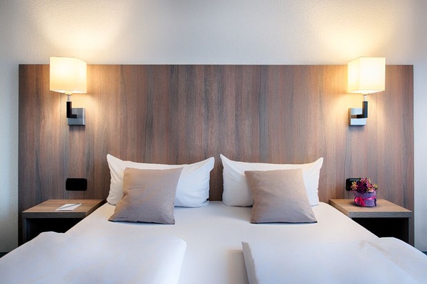 Sink into crisp linens beneath warm, calming bedside lighting.