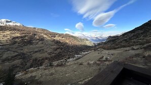 Eine Berglandschaft mit blauem Himmel und einer hölzernen Bank im Vordergrund.