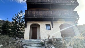 Ein mehrstöckiges Gebäude mit einem Holzbalkon, einem kleinen Fenster und einer Tür.