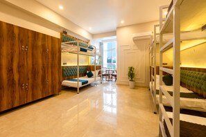 A modern room with bunk beds, a wooden wardrobe, and a seating area with a table and chairs. - Yashobhoomi Hostel  (New Delhi)