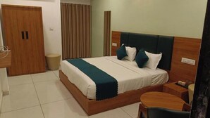 Une chambre d’hôtel avec un lit en bois, une table de chevet, une chaise, une armoire et un rideau.