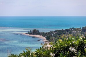 A coastal landscape with a beach, clear blue waters, and dense tropical vegetation. - Villa Napa B11 (Koh Samui)