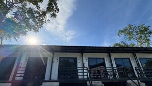 A building with a white facade, numbered rooms, and a porch with black railings. - Siqui Pods (Siquijor)