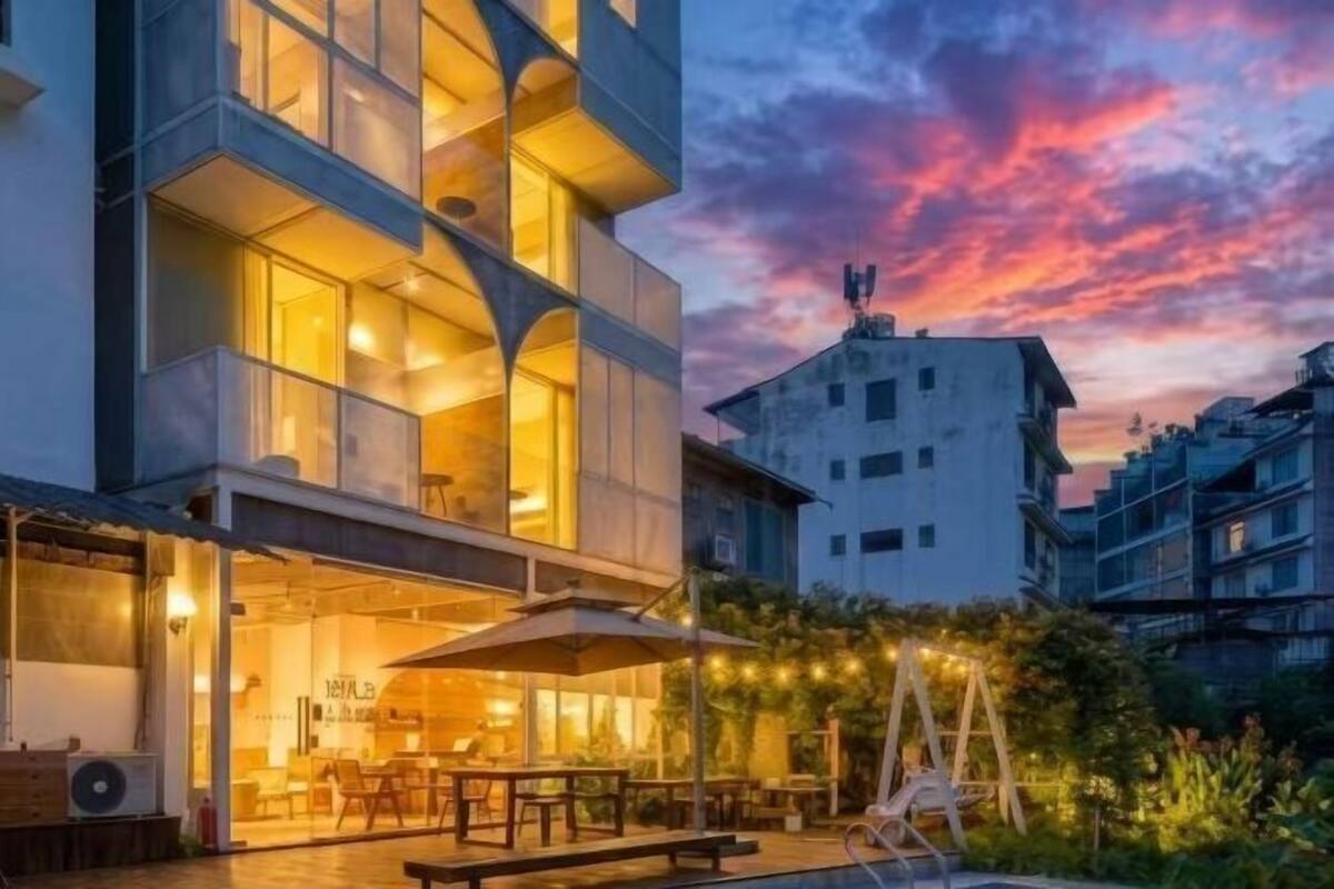 Un edificio moderno con comedor, mesas al aire libre y vista al cielo.