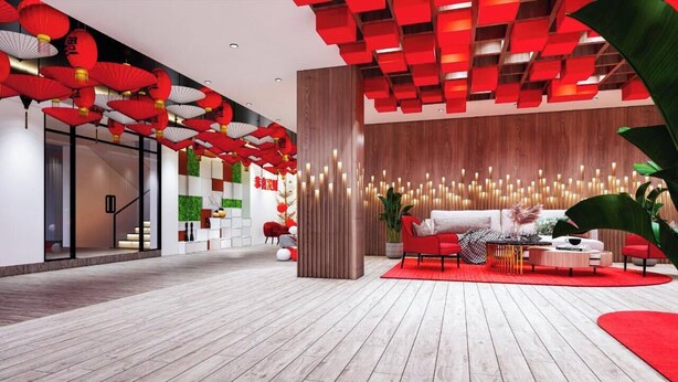 Un vestíbulo moderno con suelo de madera, zona de estar roja y faroles rojos.
