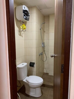 Ein kleines Badezimmer mit Toilette, Dusche und Handtrockner.
