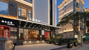 A modern hotel with a prominent entrance, outdoor seating, and a sign indicating a held event in 2026. - Sanya Coconut Dream Corri RenJoy Hotel (Sanya)